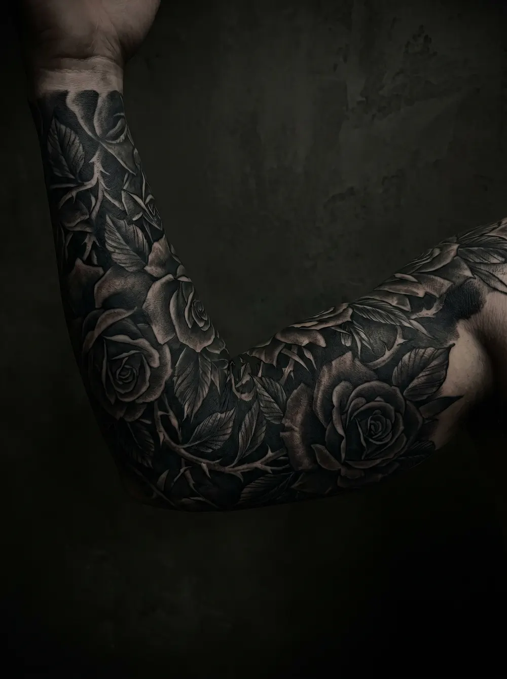 A refined botanical blackwork tattoo direction on an arm.